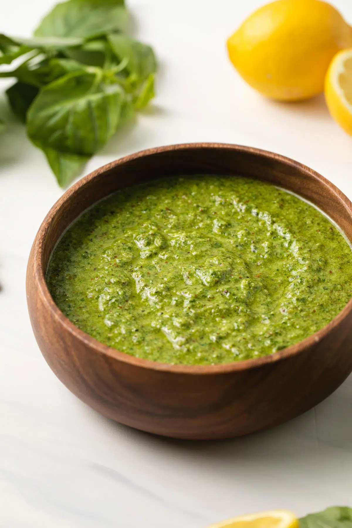 Side view of lemon pesto in a wooden bowl.