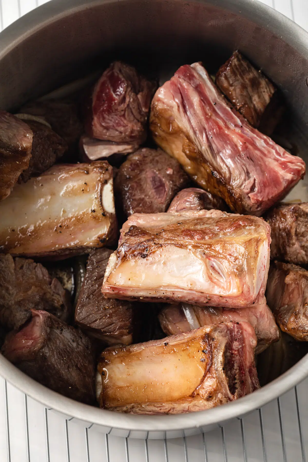 Browned beef and short ribs in a stock pot.