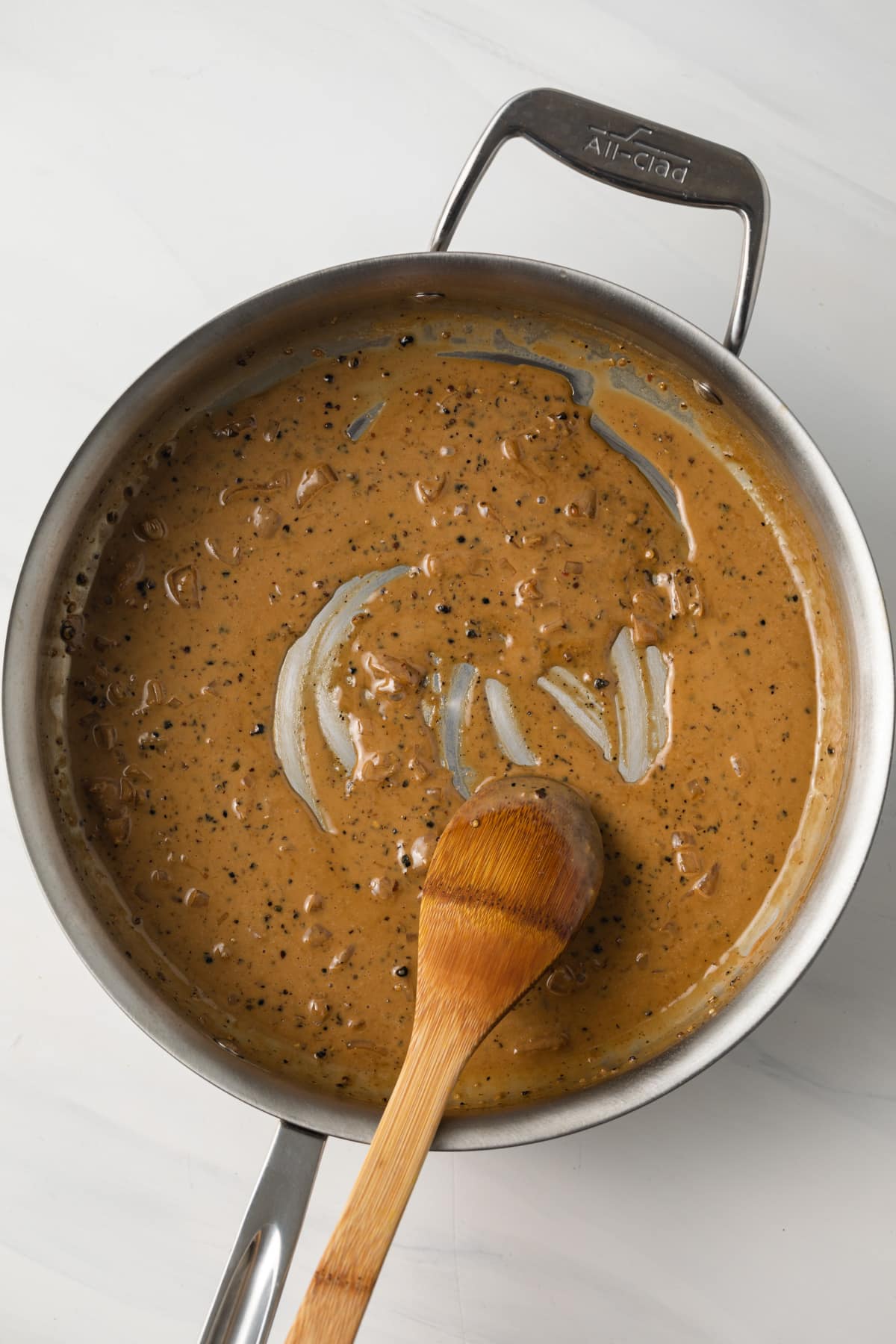 Creamy peppercorn sauce in a skillet.