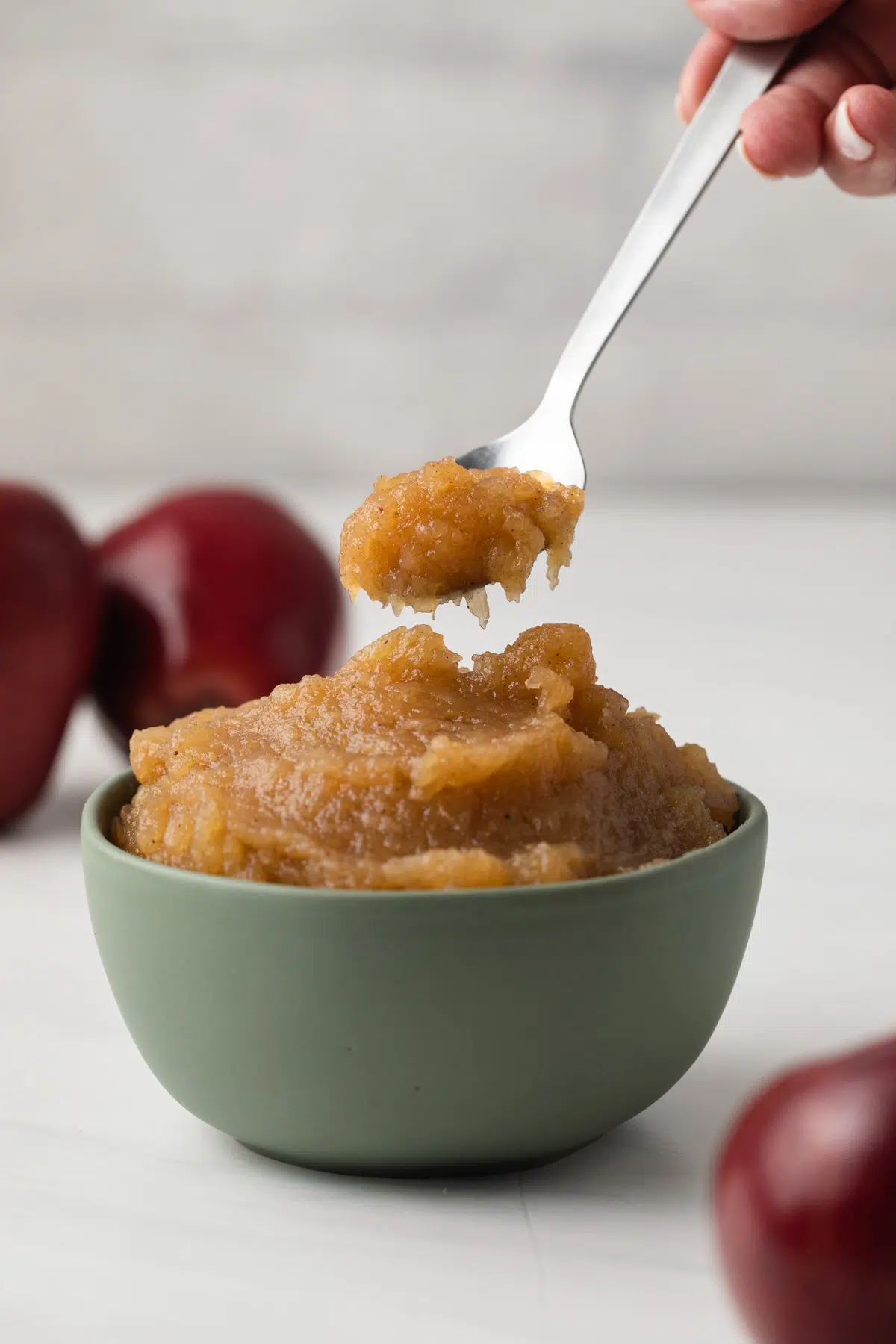 Easy applesauce on a spoon and in green bowl.