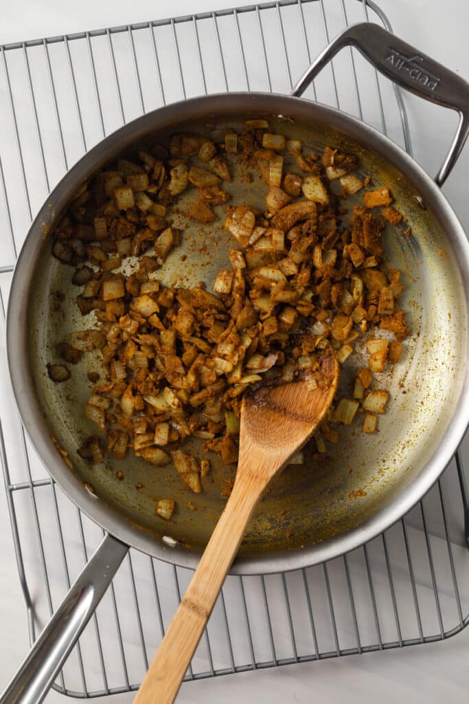 Sauteed onions with spices in skillet.