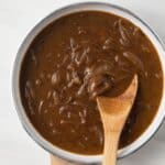 Onion gravy in a white fry pan.