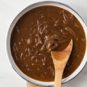 Onion gravy in a white fry pan.