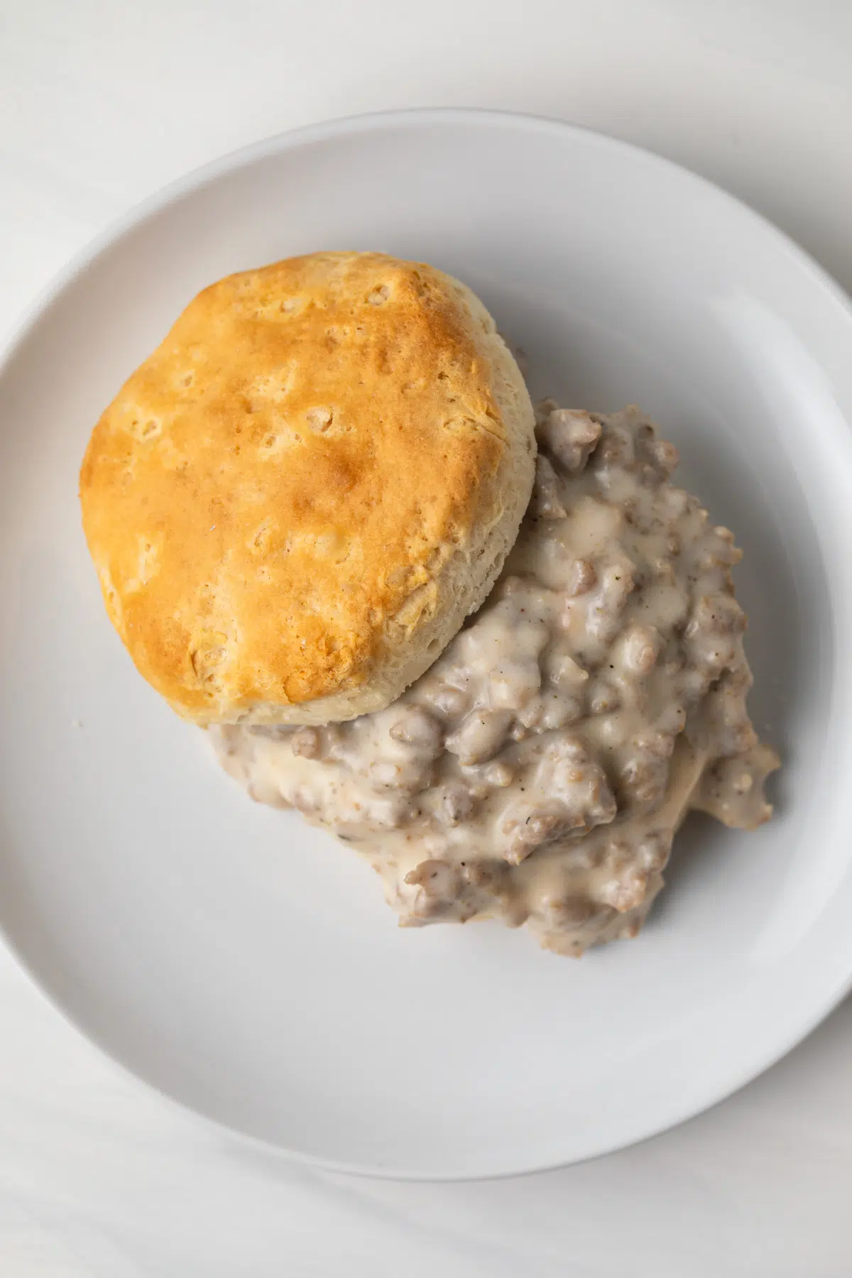 Overhead view of sausage gravy on a biscuits.