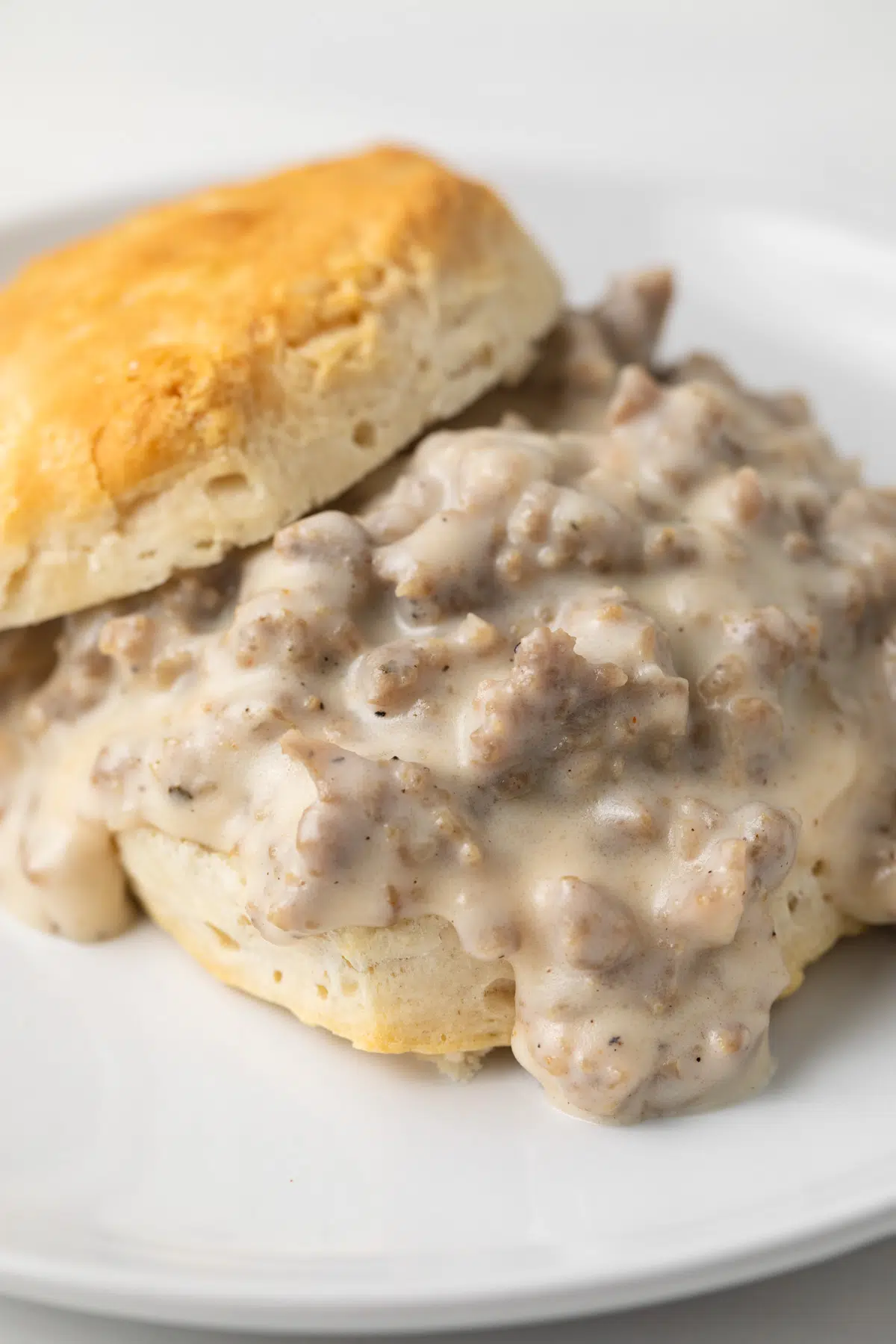 Side view of sausage gravy on a biscuit.