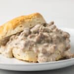 Side view of sausage gravy on a biscuit.