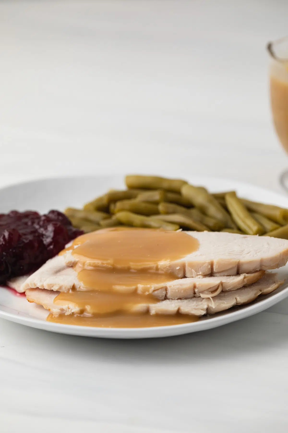 Side view of turkey slices covered in turkey gravy.