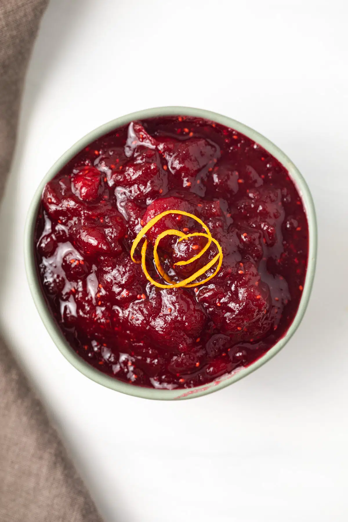 Overhead of cranberry sauce in green bowl.