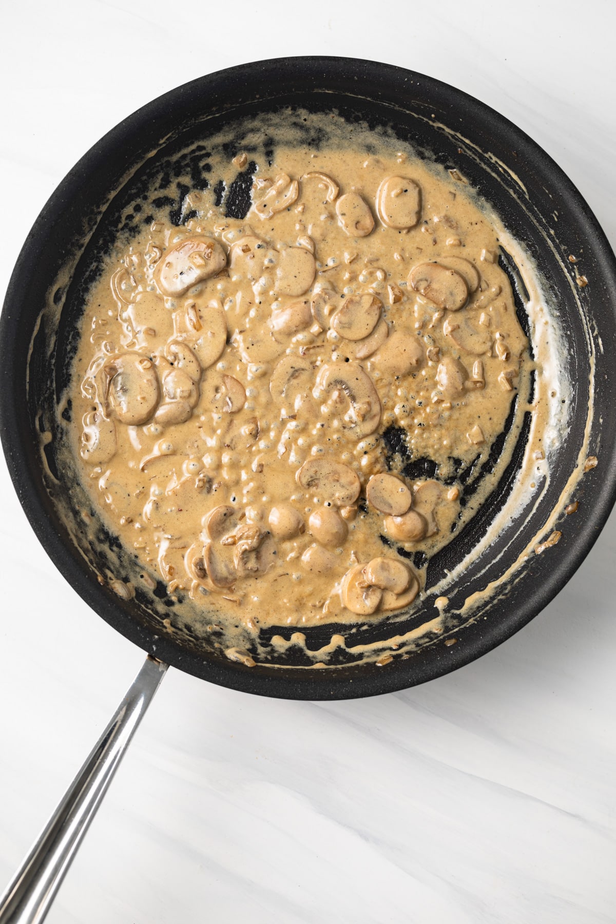 Mushrooms and cream in a skillet.