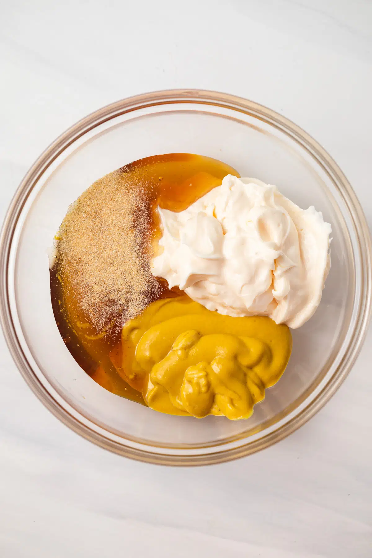 Honey mustard ingredients in glass bowl.