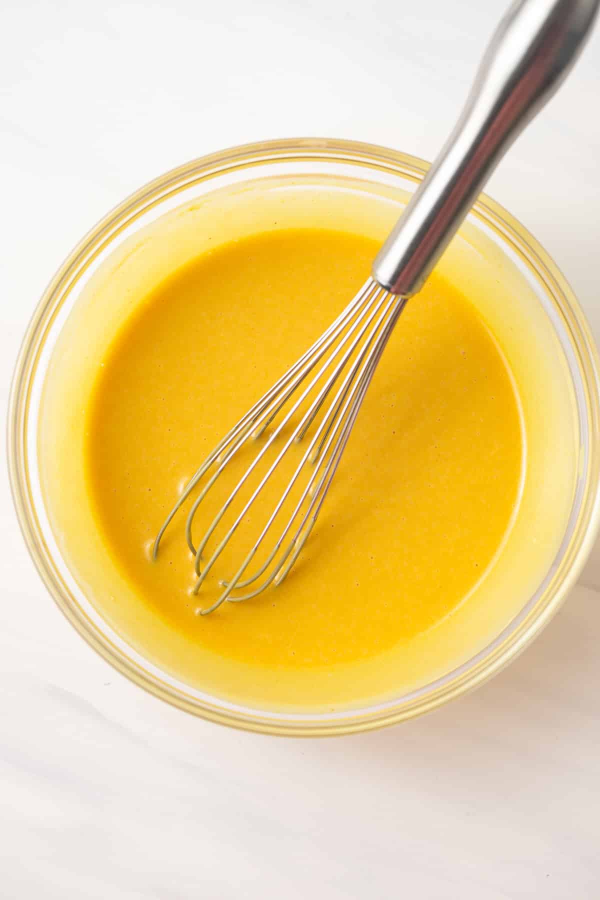 Honey mustard dressing in glass bowl.