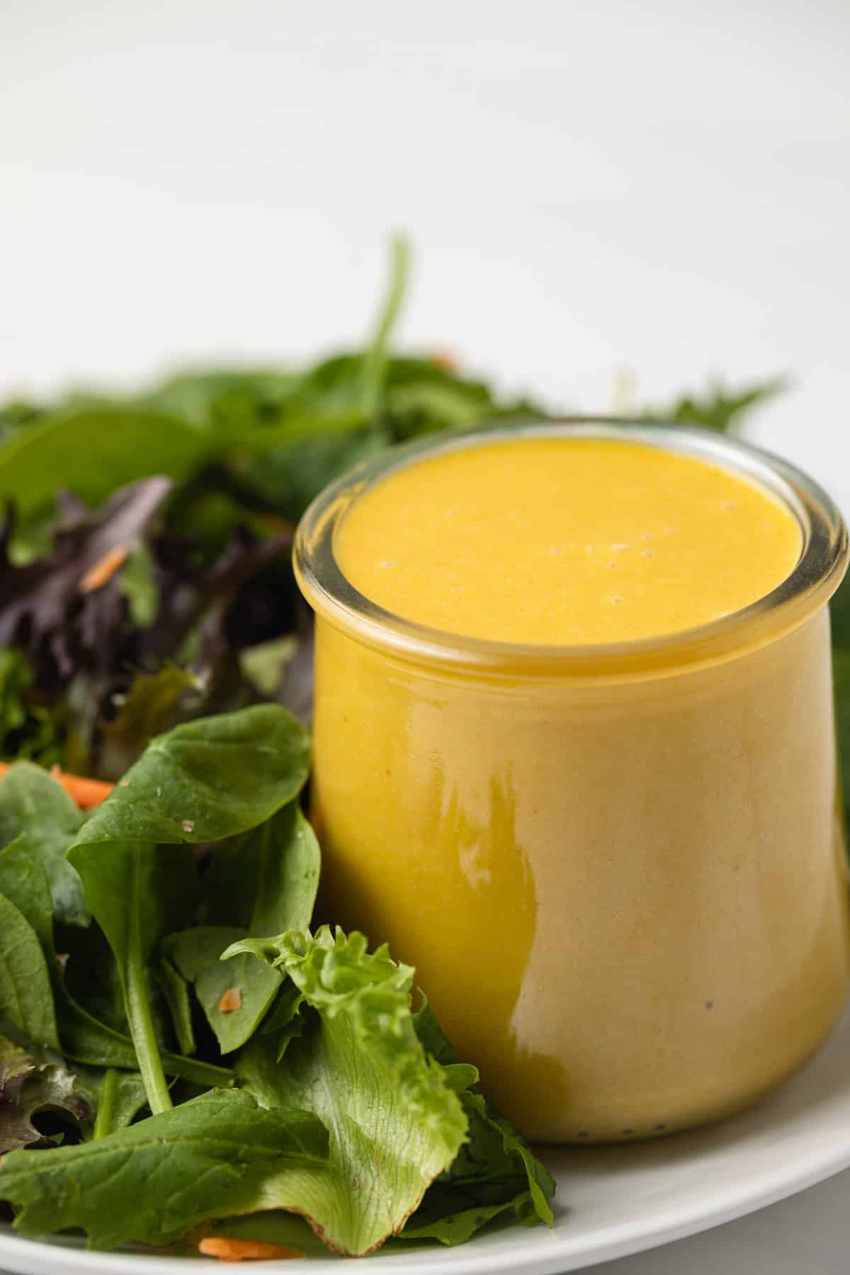 Side view of extra creamy honey mustard in glass jar.