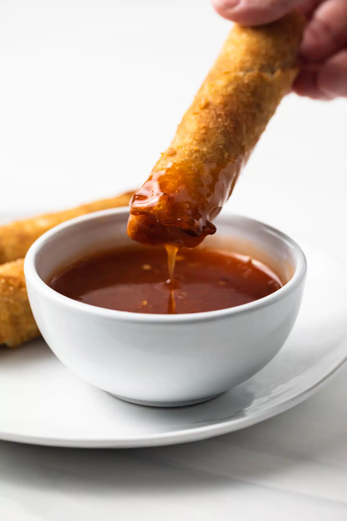 Eggroll dipped in sweet chili sauce.