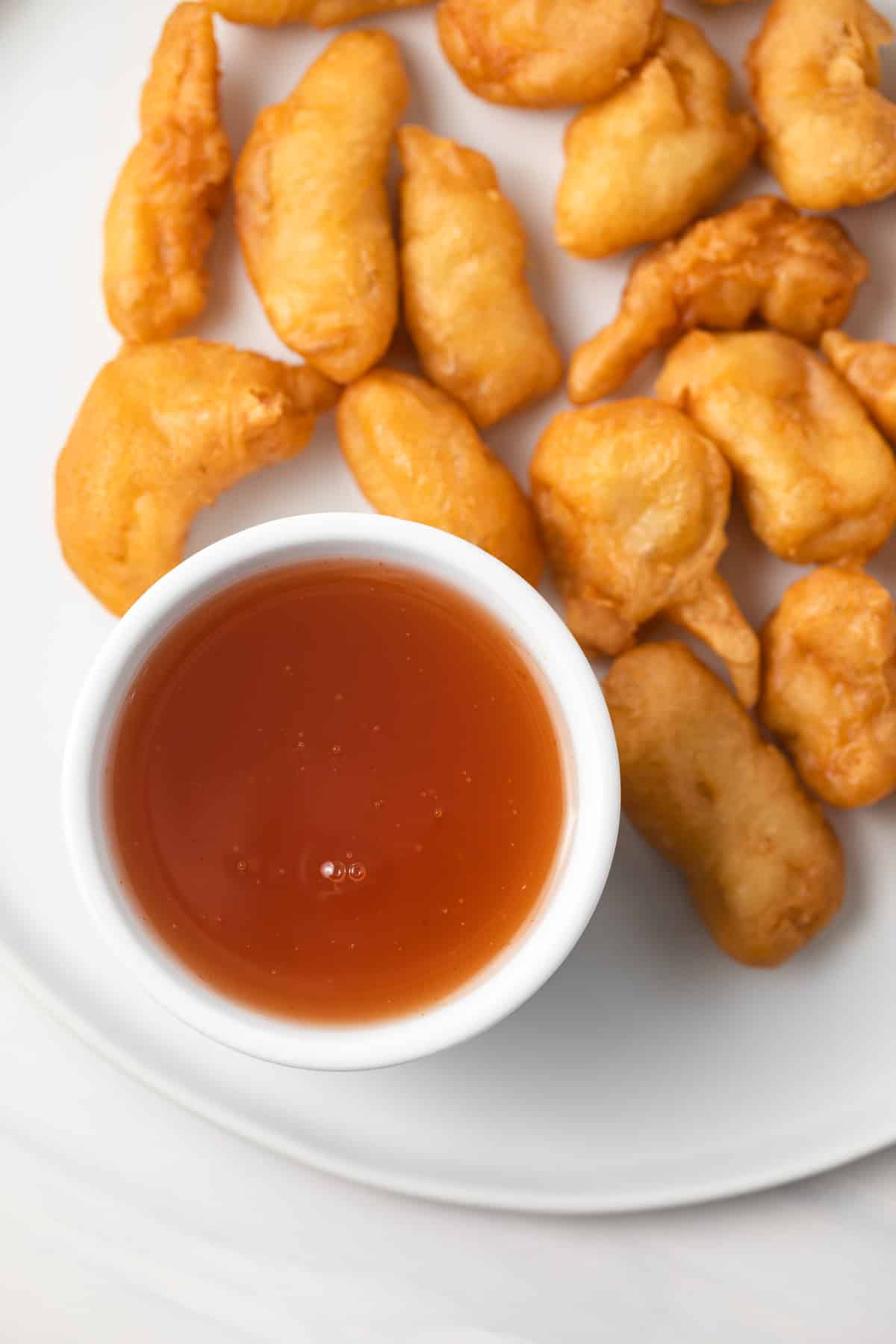 Overhead of sweet and sour sauce in a white bowl.