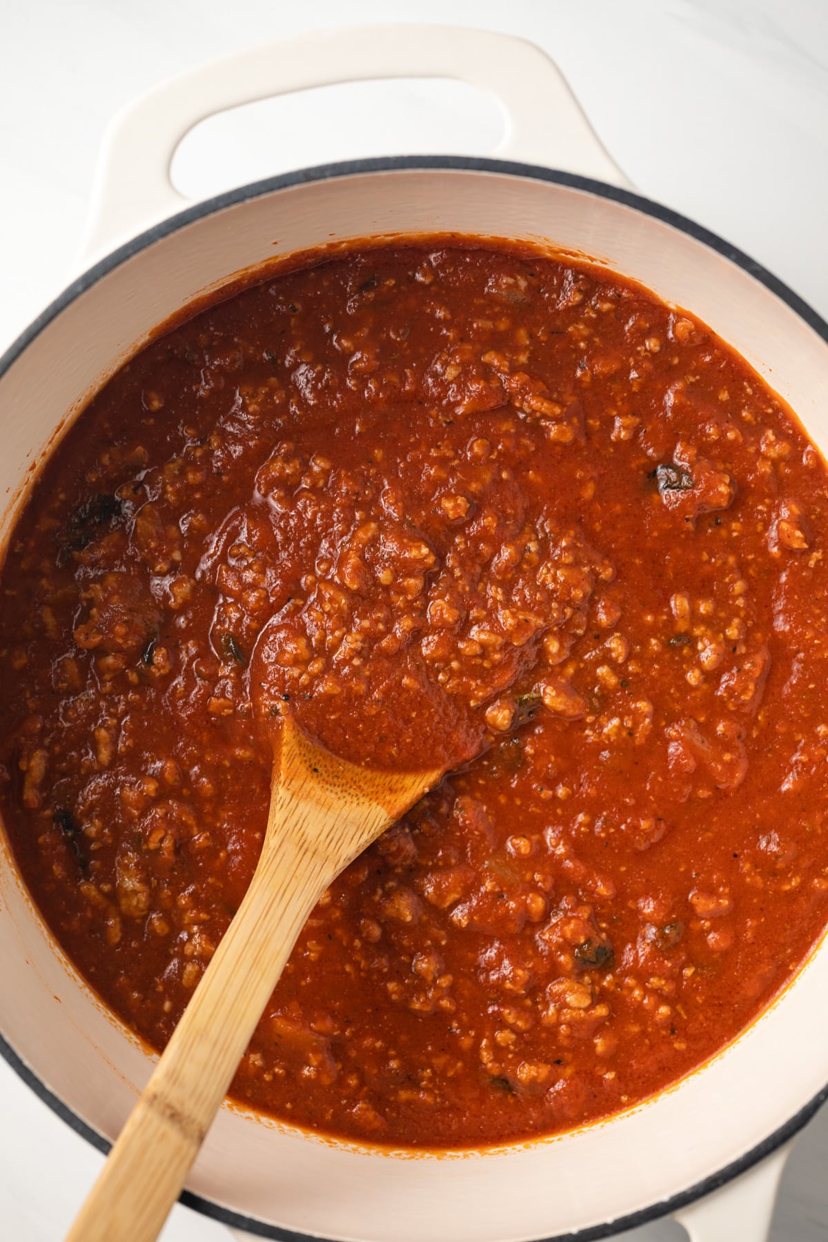 Ground turkey meat sauce with spoon in saucepan.