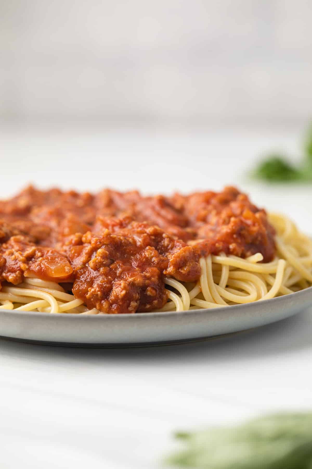Ground turkey meat sauce over spaghetti on a plate.