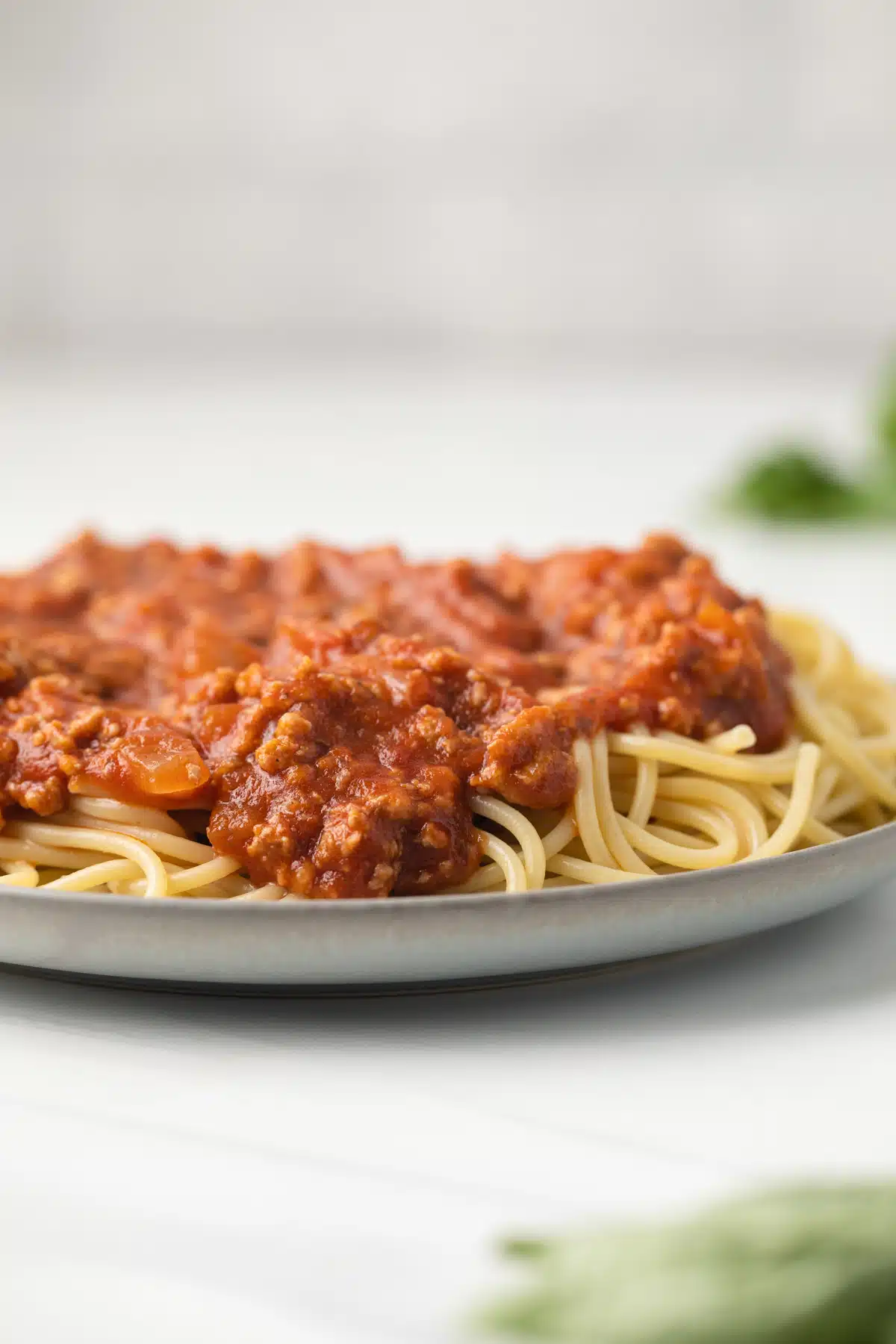 Ground turkey meat sauce over spaghetti on a plate.