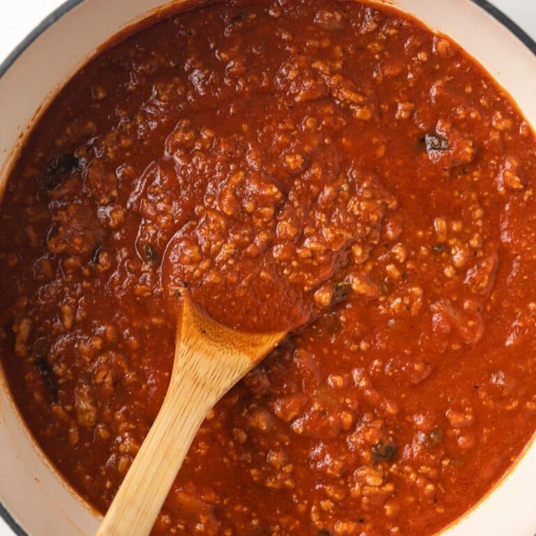 Ground turkey meat sauce with spoon in saucepan.