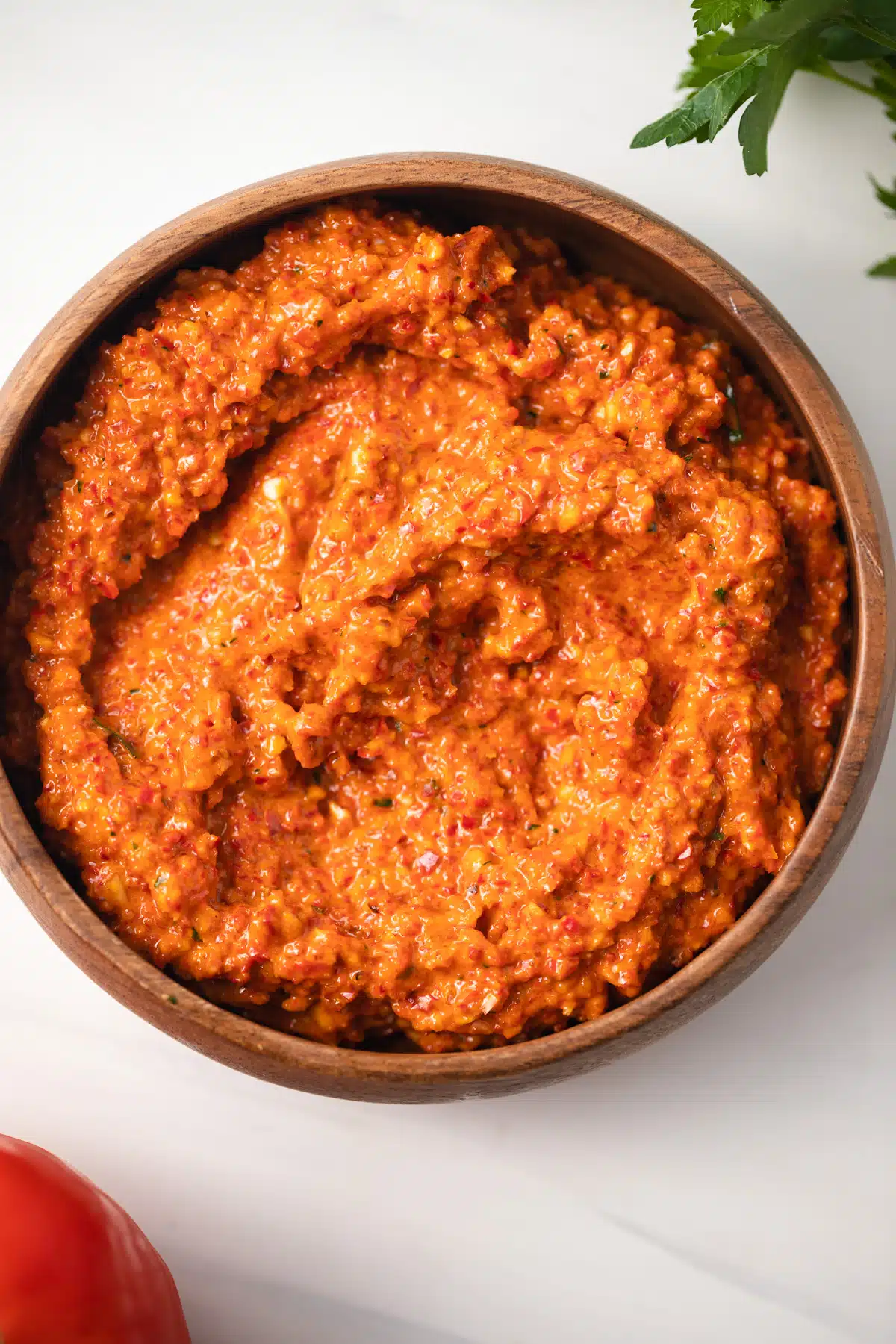 Red pepper romesco in brown bowl.