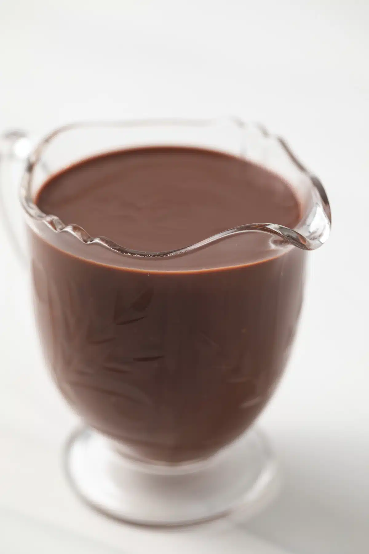 Chocolate sauce in small glass pitcher.