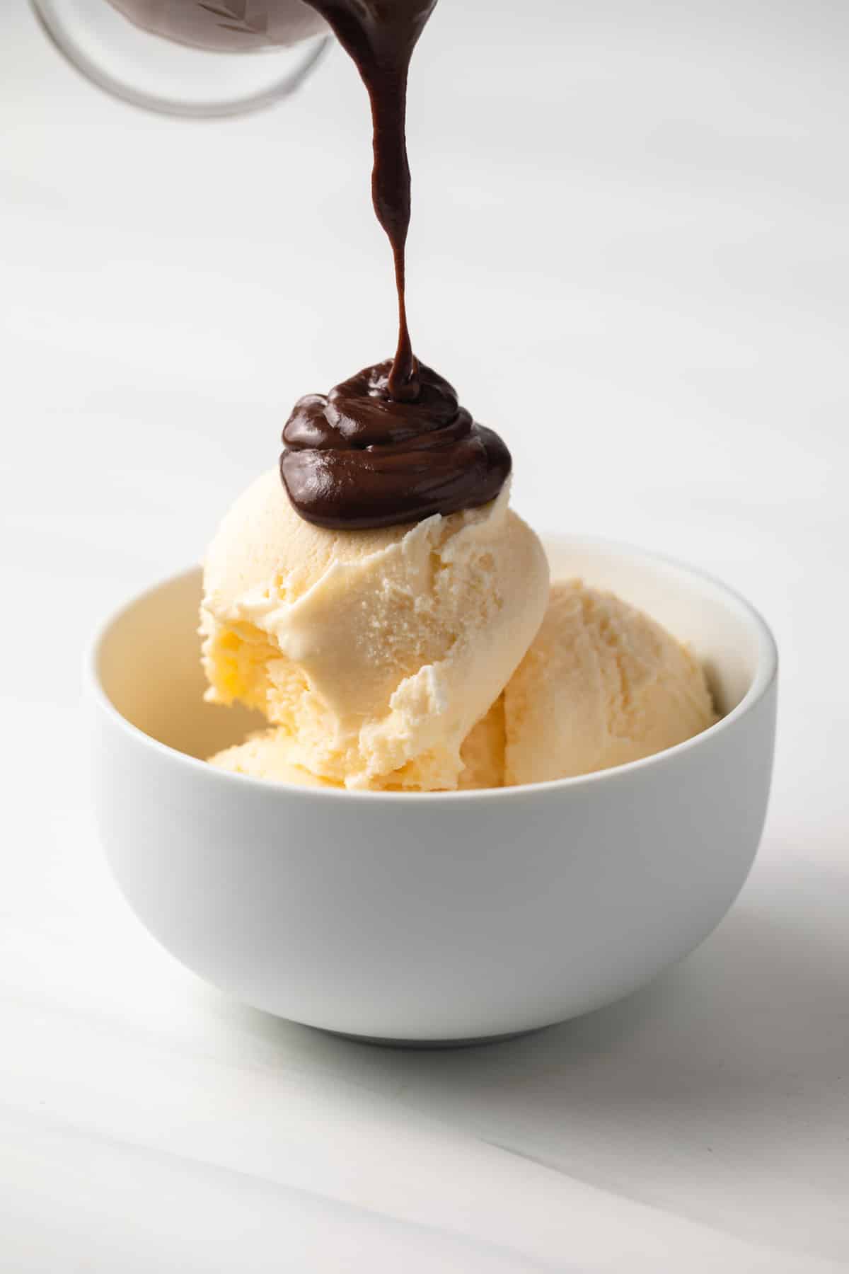 Chocolate sauce poured over vanilla ice cream.