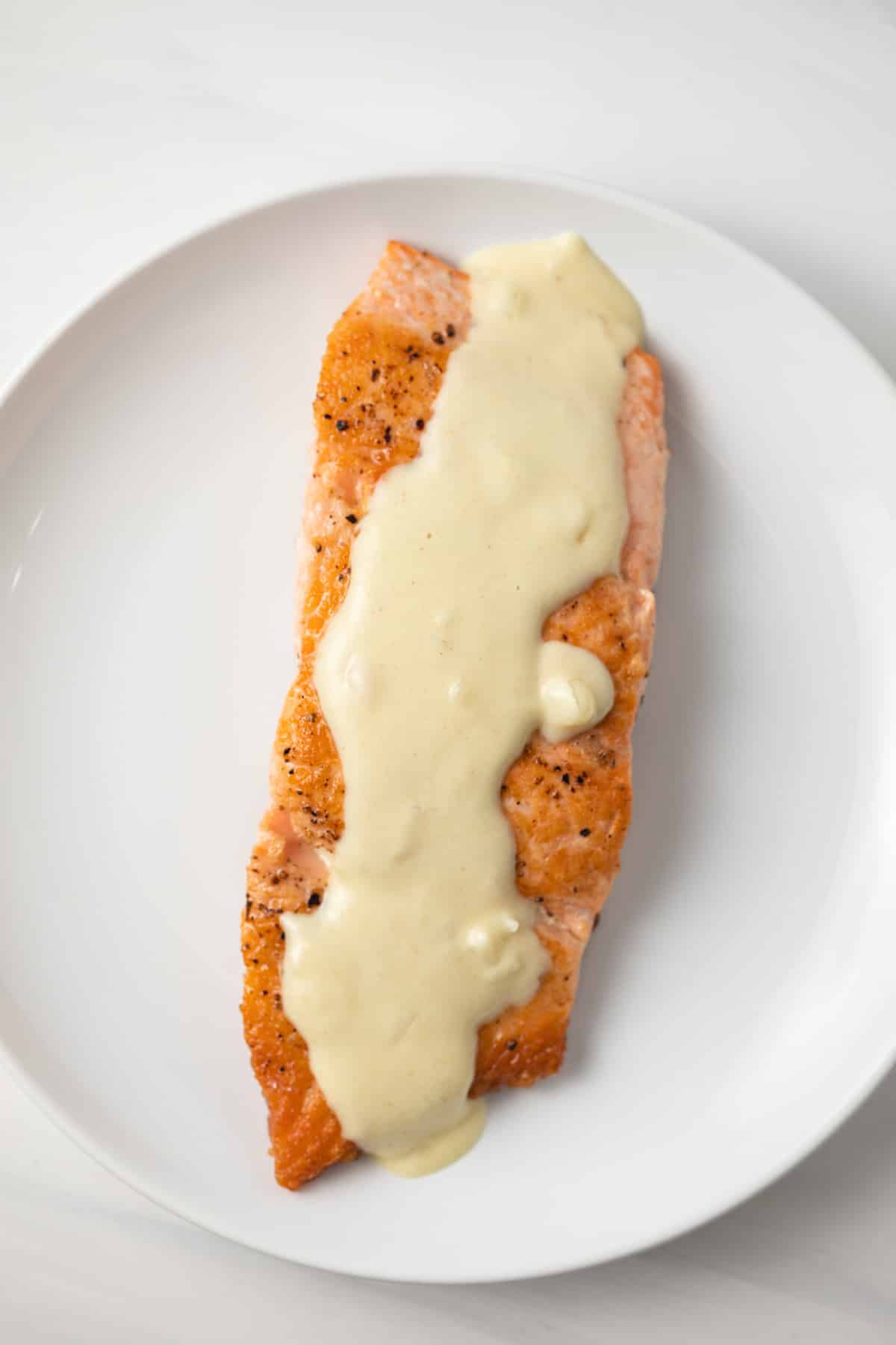 overhead of dijon mustard sauce over salmon.