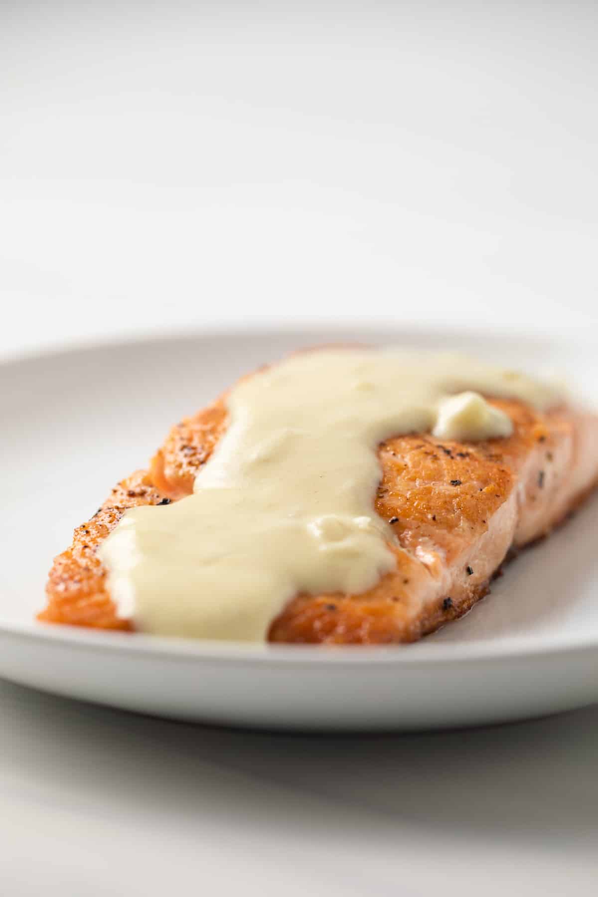 Side view of dijon mustard sauce over salmon.