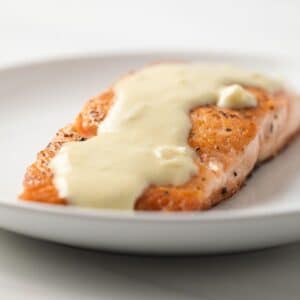 Side view of dijon mustard sauce over salmon.