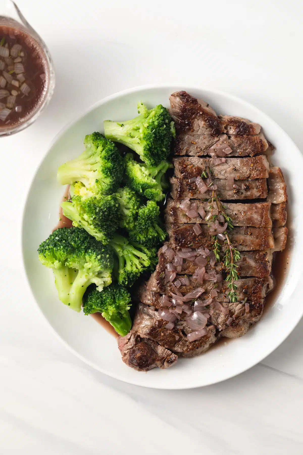 Red wine sauce over steak with broccoli.