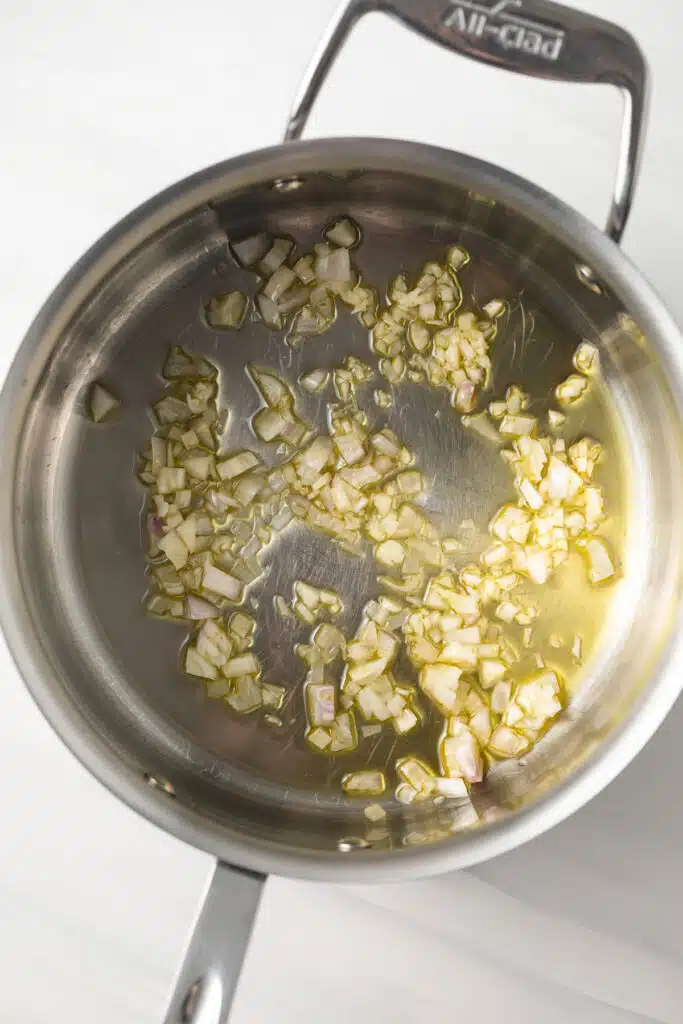 Shallots and garlic cooking in a saucepan.
