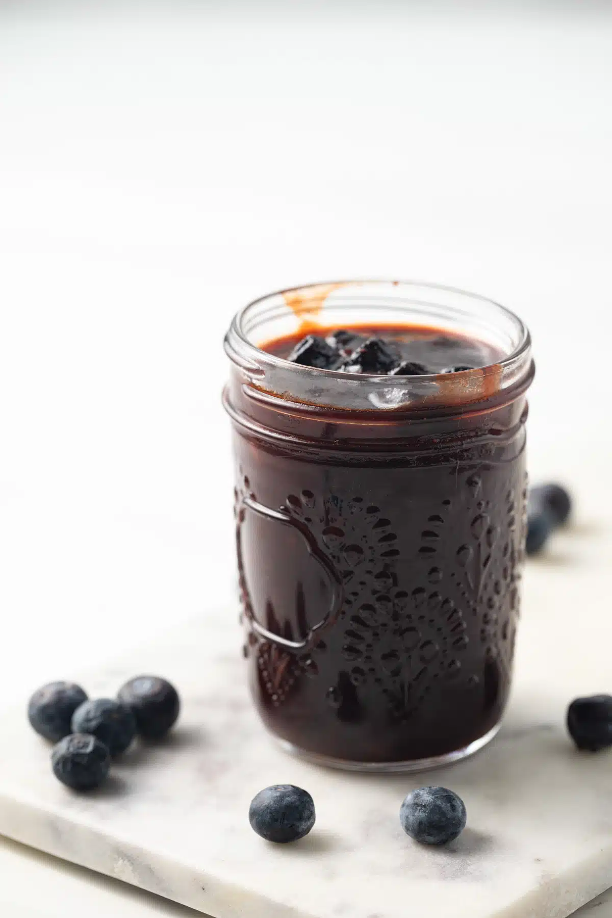 Side view of blueberry BBQ sauce in a jar.