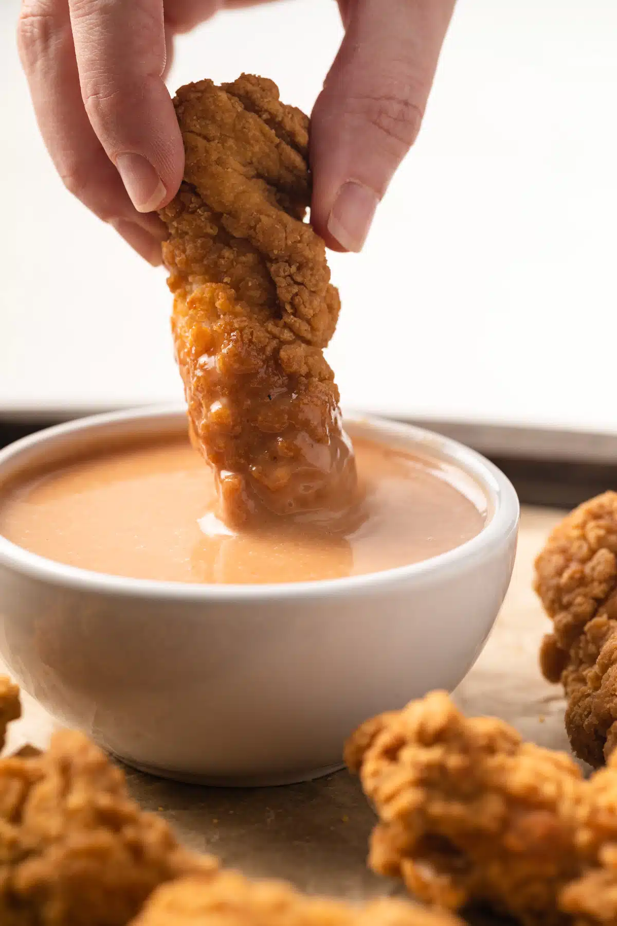 Dipping a chicken nugget in dipping sauce.