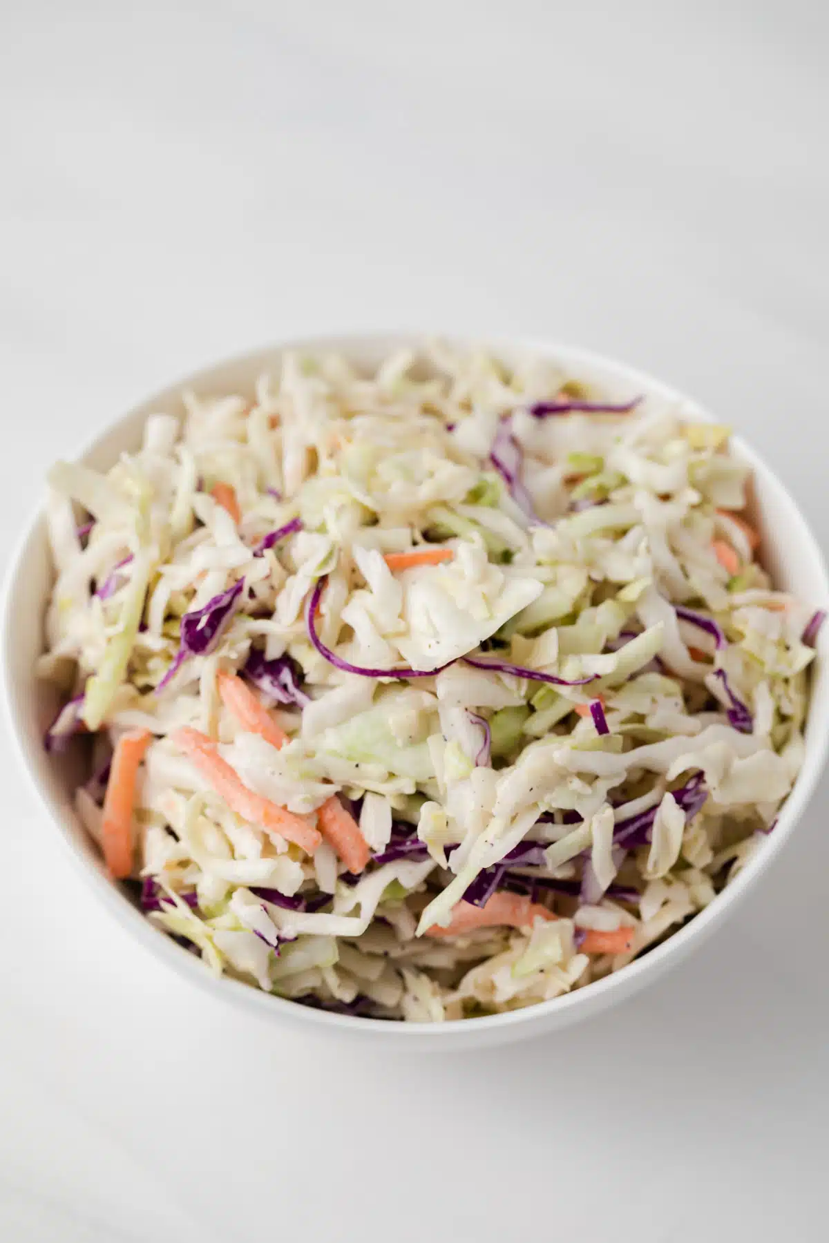 High angled view of slaw coated in coleslaw dressing.