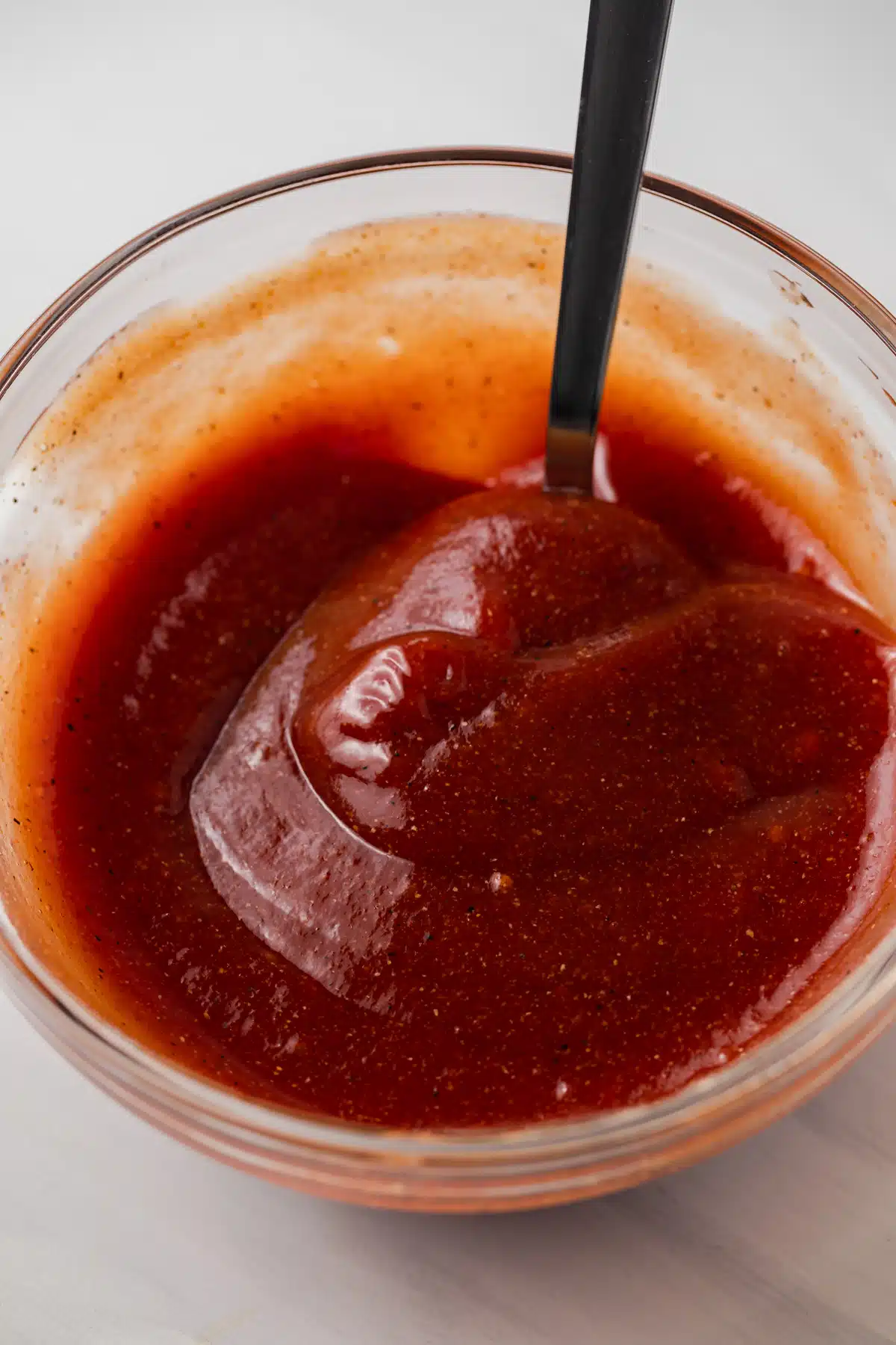 Angled view of meatloaf sauce in glass bowl.