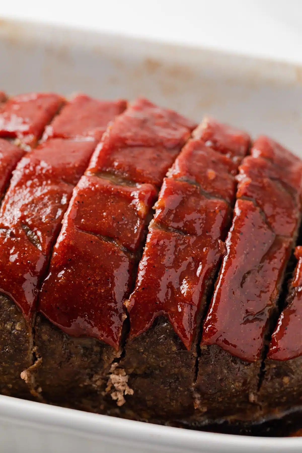 Sliced meatloaf with meatloaf sauce on top.