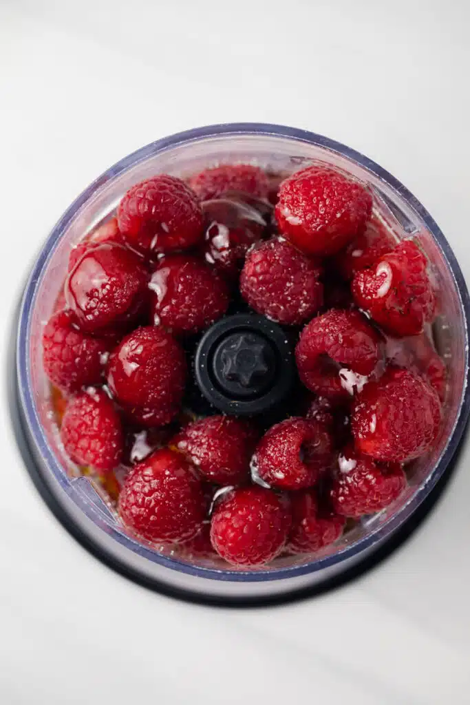 Berries with oil and honey in a food processor.