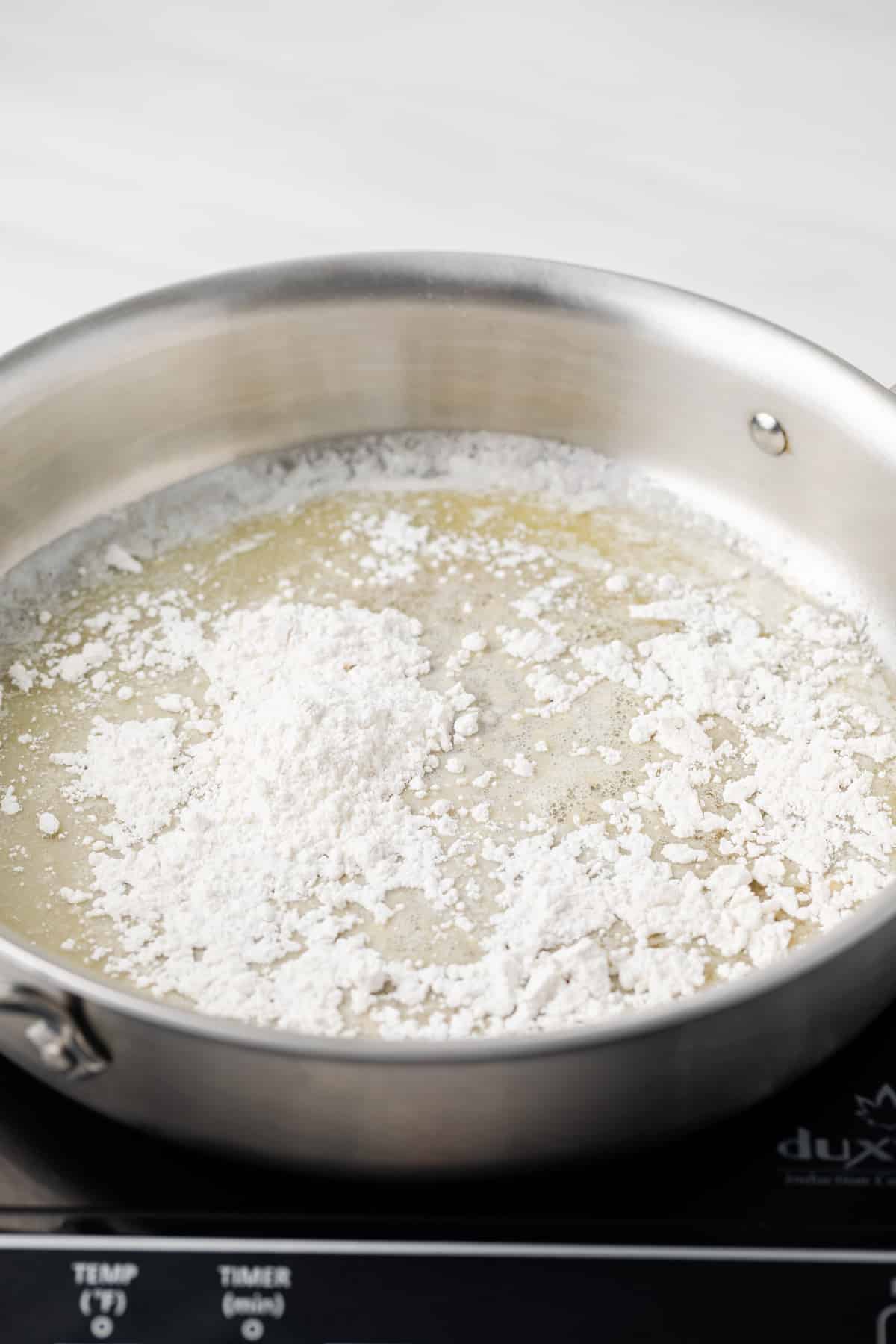 Flour sprinkled over melted butter in skillet.