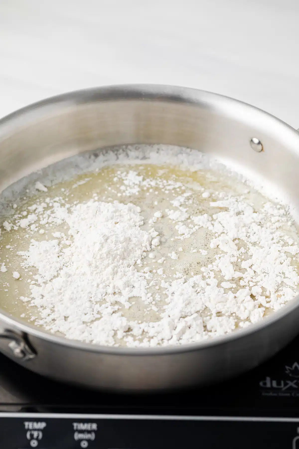 Flour sprinkled over melted butter in skillet.