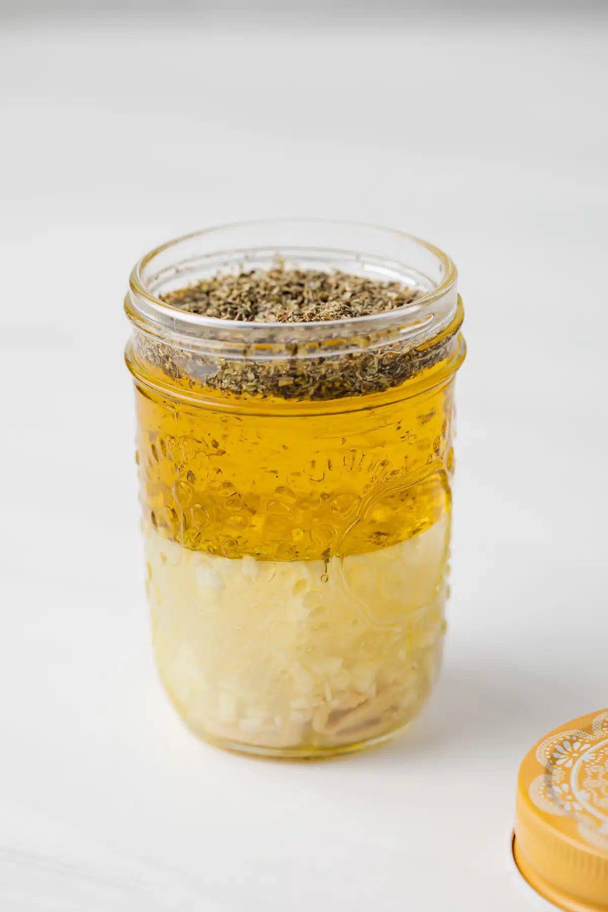 Italian dressing chicken marinade in a glass jar without a lid.