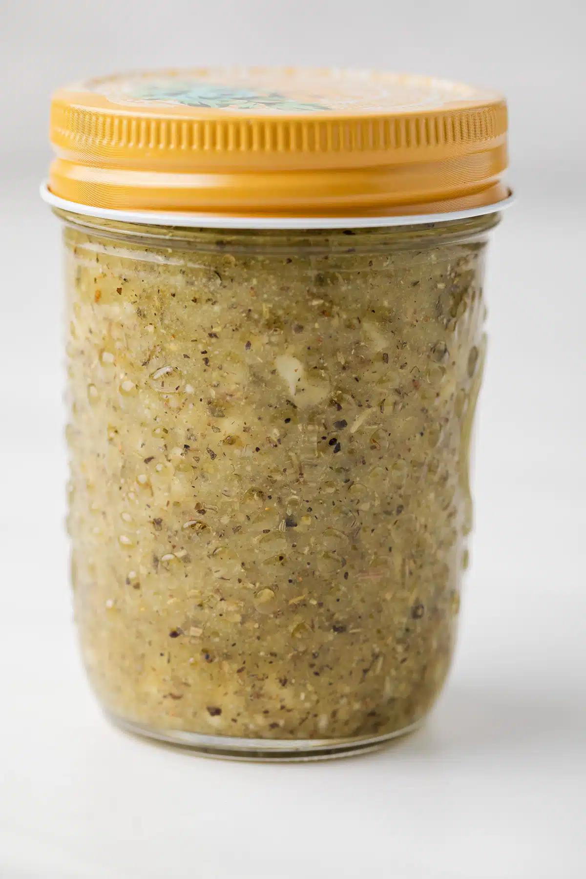 Italian dressing chicken marinade in a glass jar with a lid.