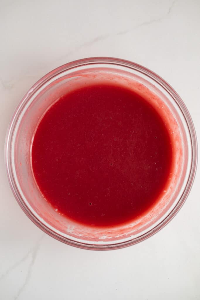 Raspberry sauce in a glass bowl.