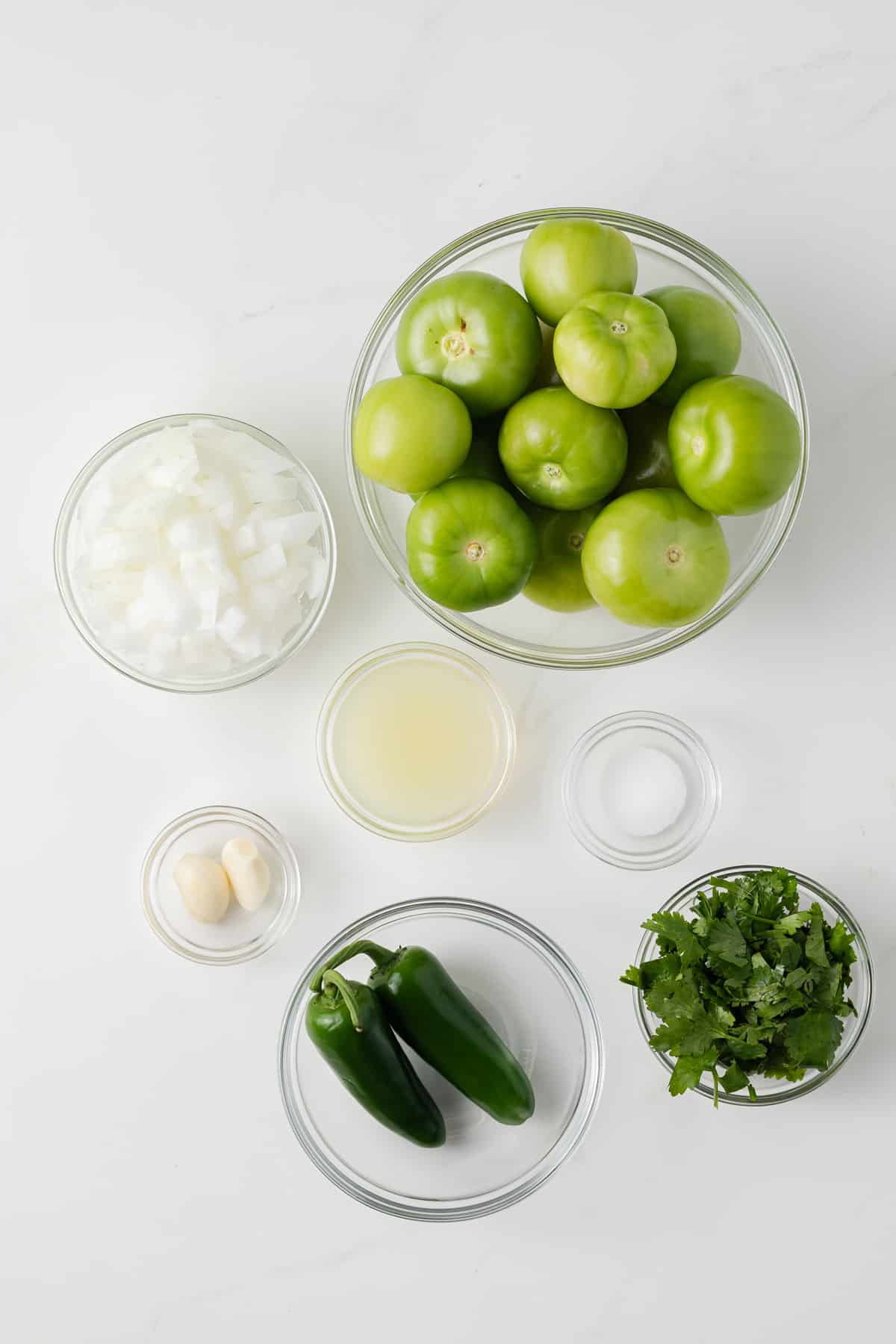 Ingredients for salsa verde in glass bowls.