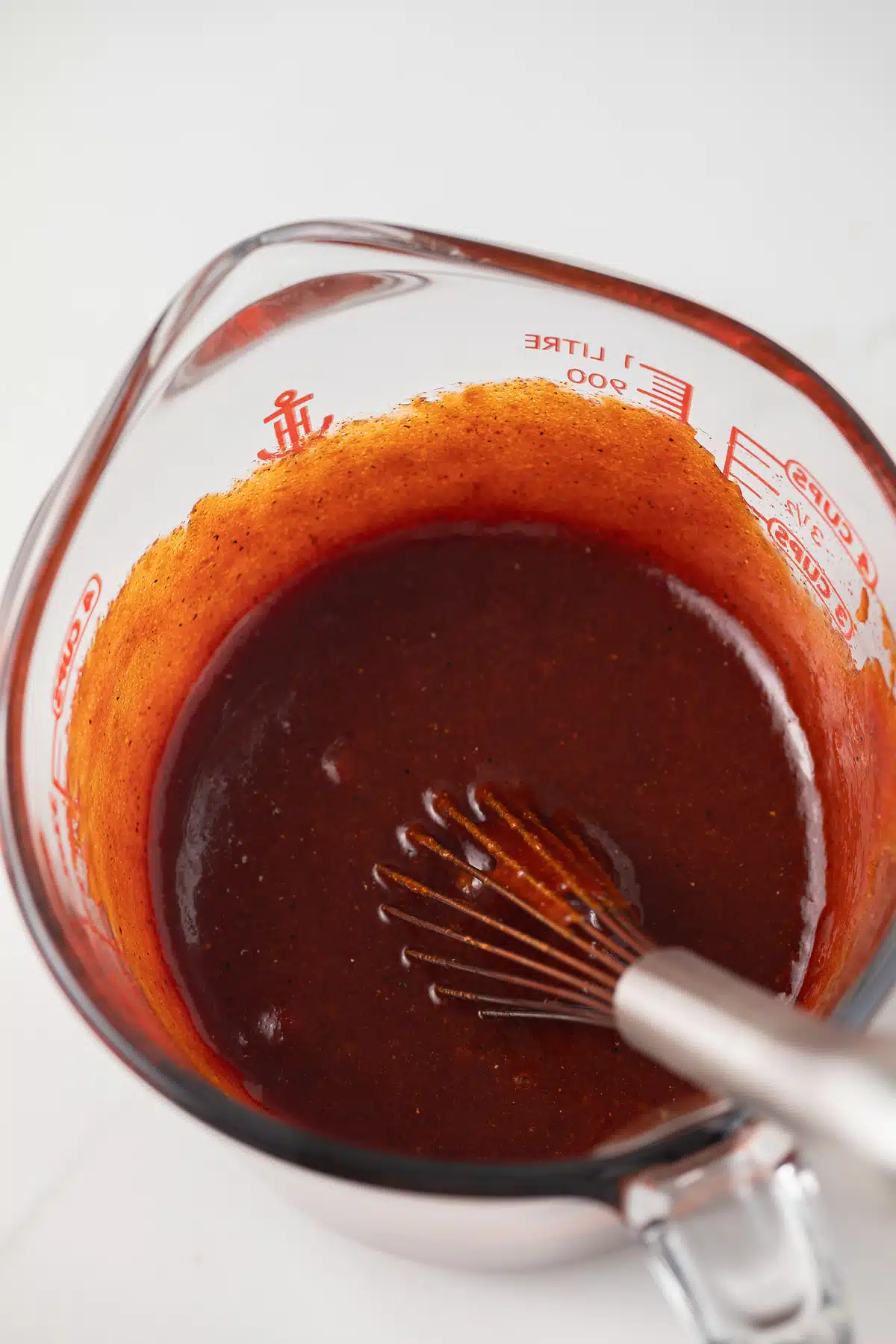 Spicy chicken marinade in glass measuring cup.