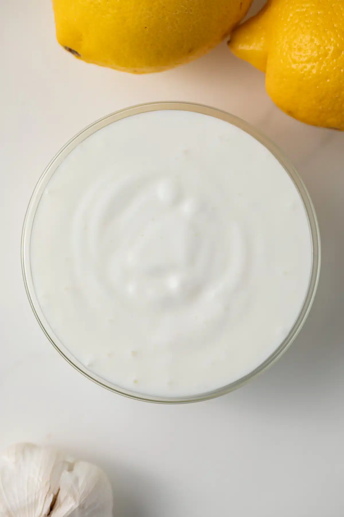 Overhead view of yogurt garlic sauce in glass bowl.