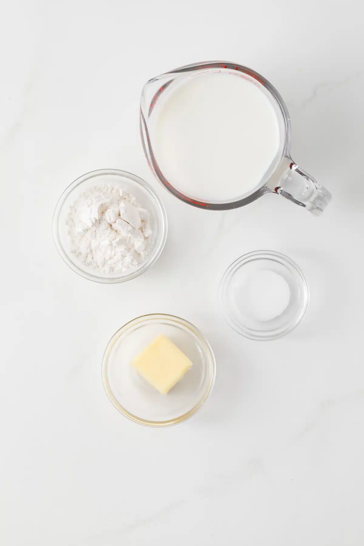 Ingredients for Basic White Sauce (Béchamel) in glass bowls.
