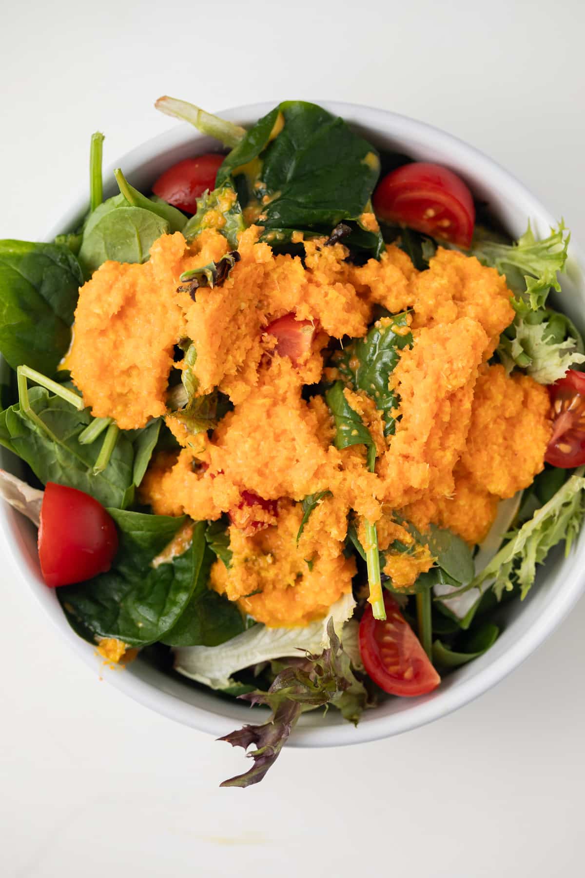 Overhead view of carrot ginger dressing on salad.