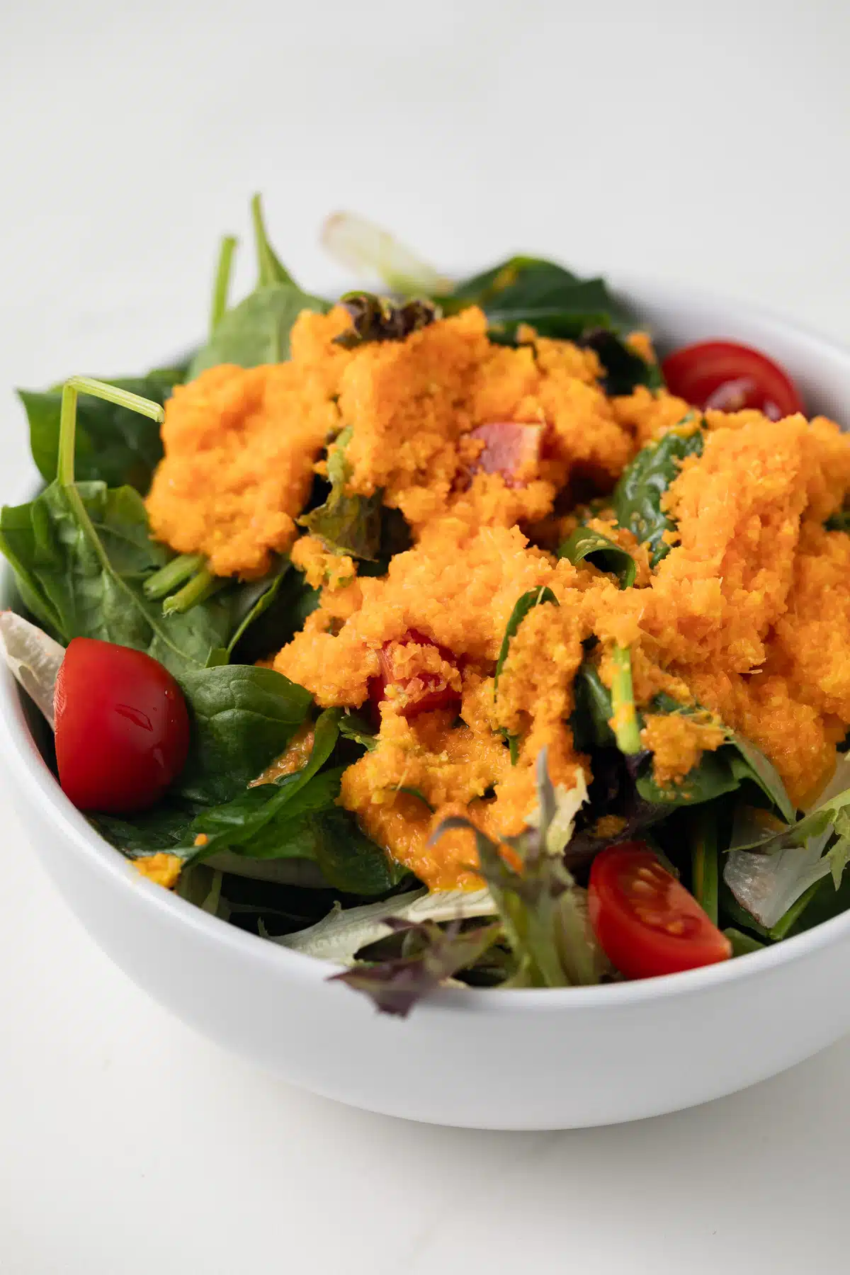 Side view of Carrot Ginger Dressing on salad.