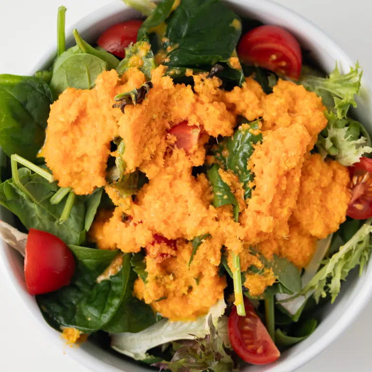 Overhead view of carrot ginger dressing on salad.