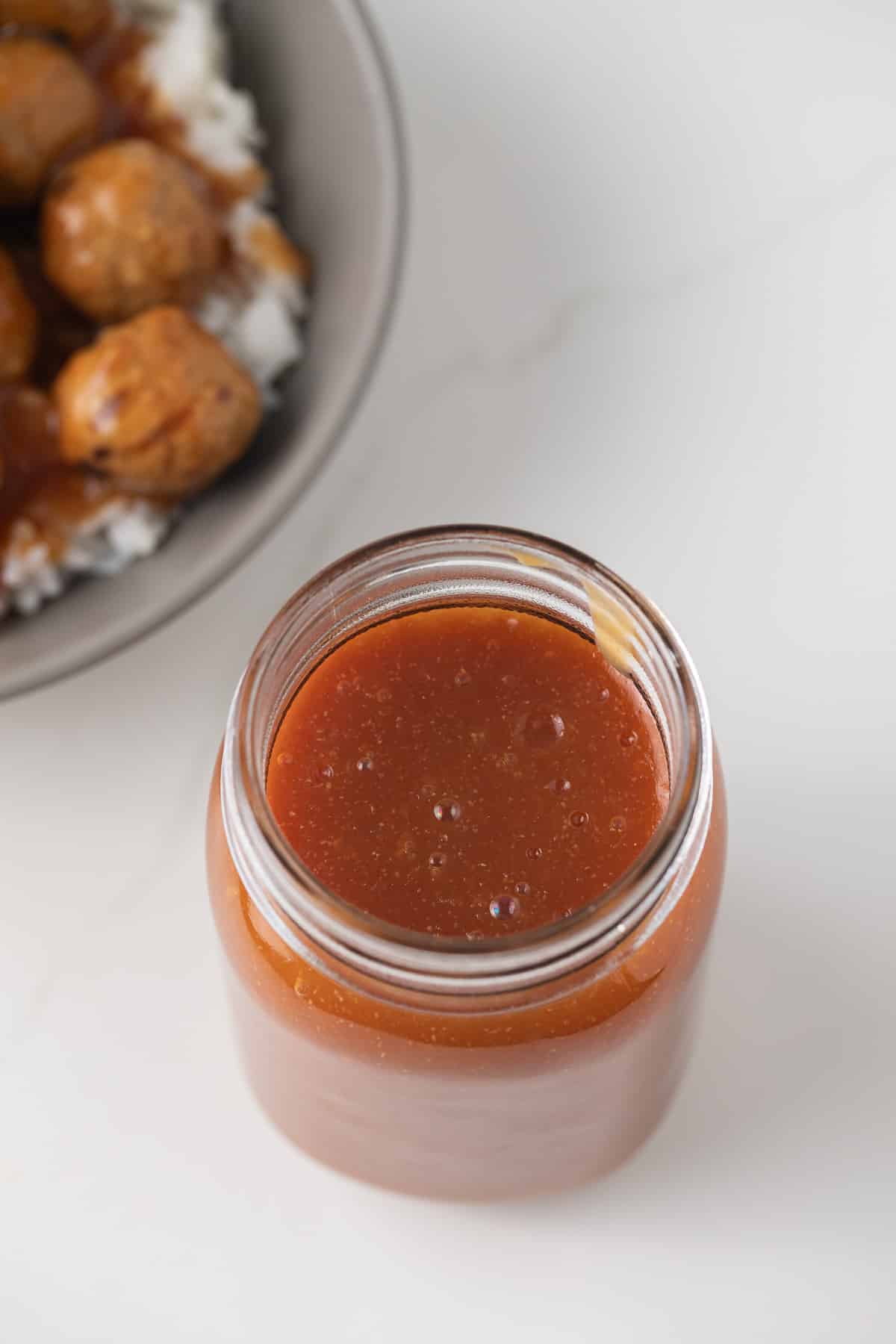 Pineapple orange sauce in a glass jar.