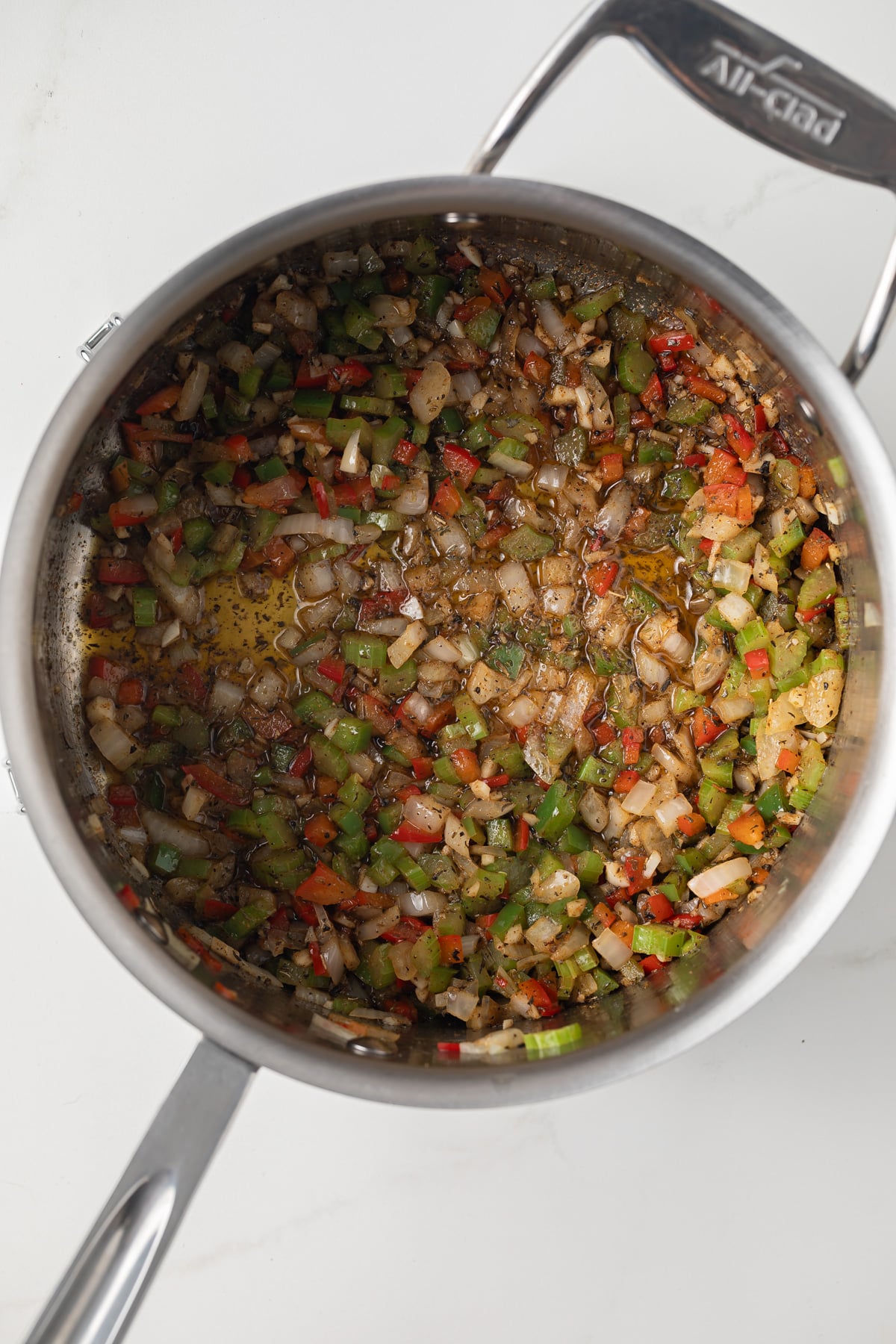 Sauteed veggies with spices in saucepan.